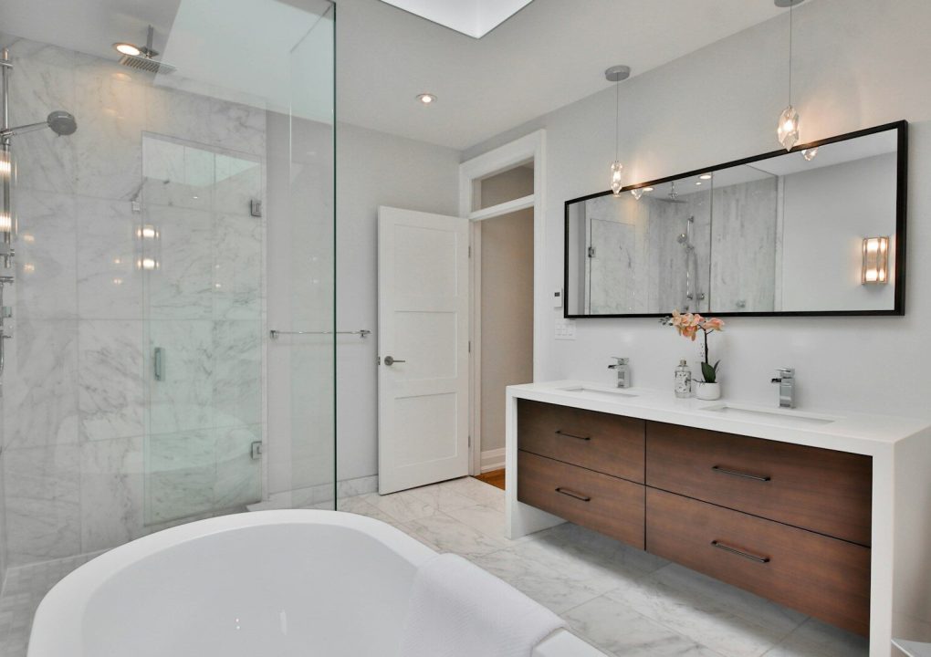 a bathroom with a large white bathtub next to a walk in shower