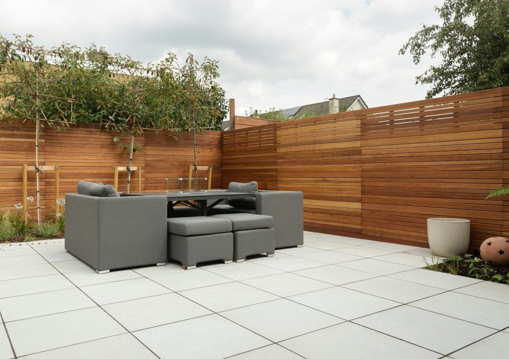 a patio with a couch and a table and chairs